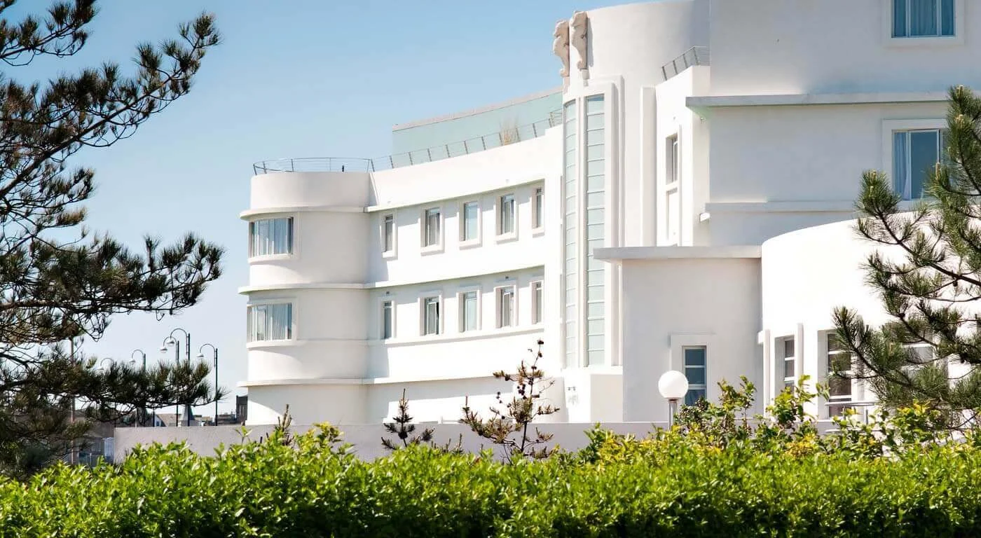 The curved white building of the Midland hotel among pine trees